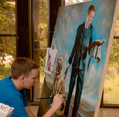 Young man using brush to paint on canvas