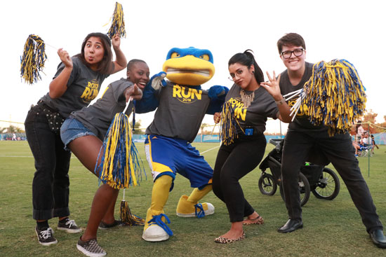 CSUB students with Rowdy mascot and a random stroller in the background