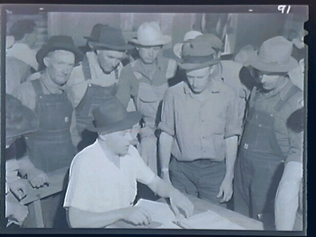 Migrant workers gather around in the Arvin relief office.