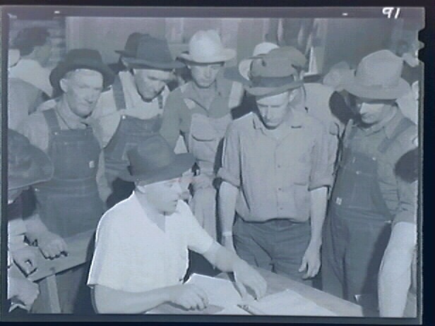 Migrant workers gather around in the Arvin relief office