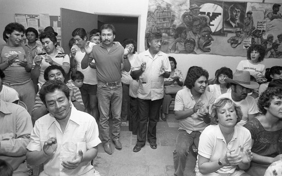 Cesar Chavez and a group applauding. 