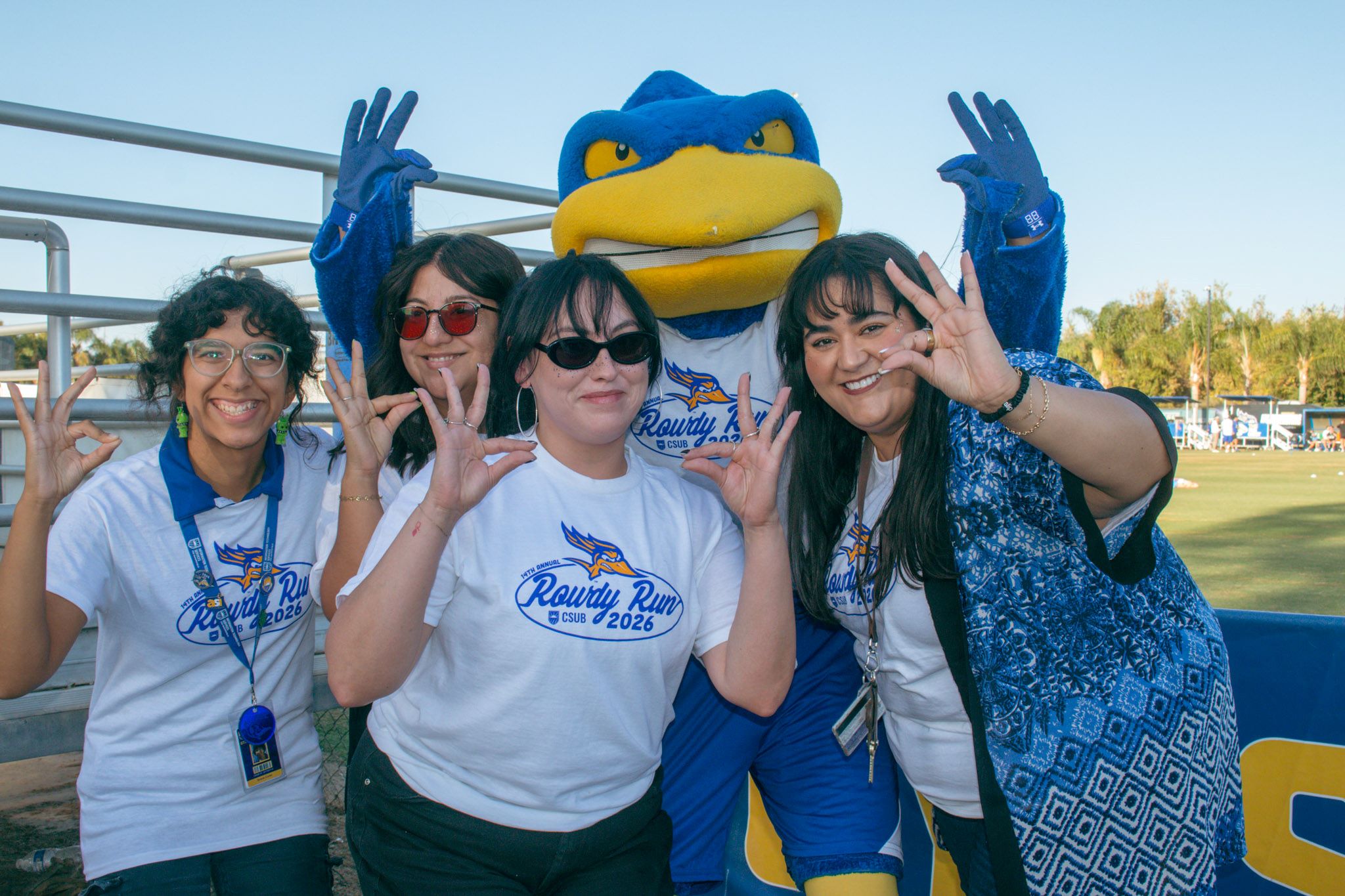 CSUB students and staff pose with Rowdy while wearing the white 2026 Rowdy Run T-shirt