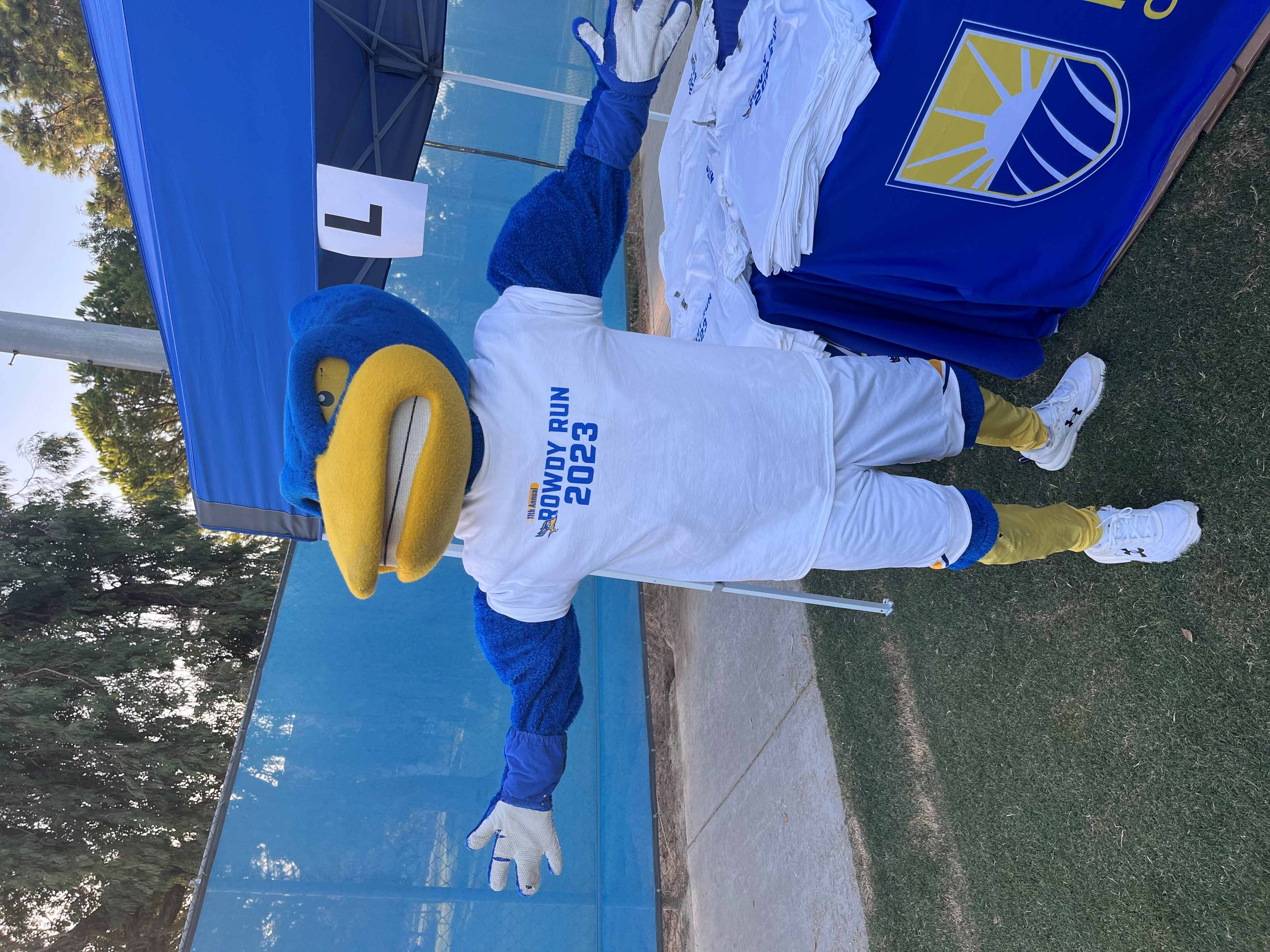 Rowdy mascot wearing and posing with a white Rowdy Run 2023 T-shirt