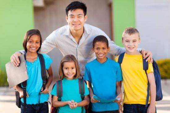 Teacher standing behind four young students