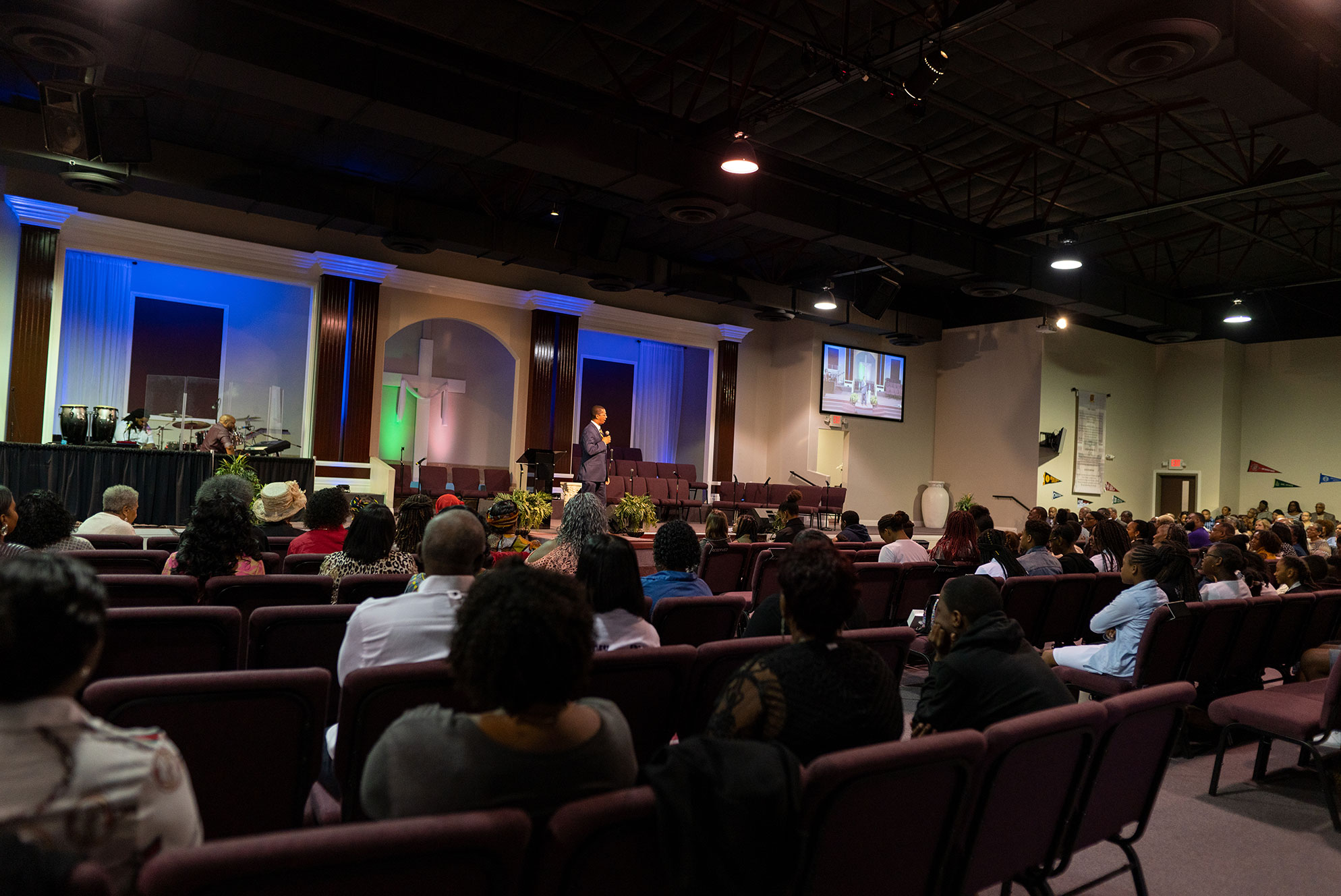 Group of people in a church listening to pastor speak on stage