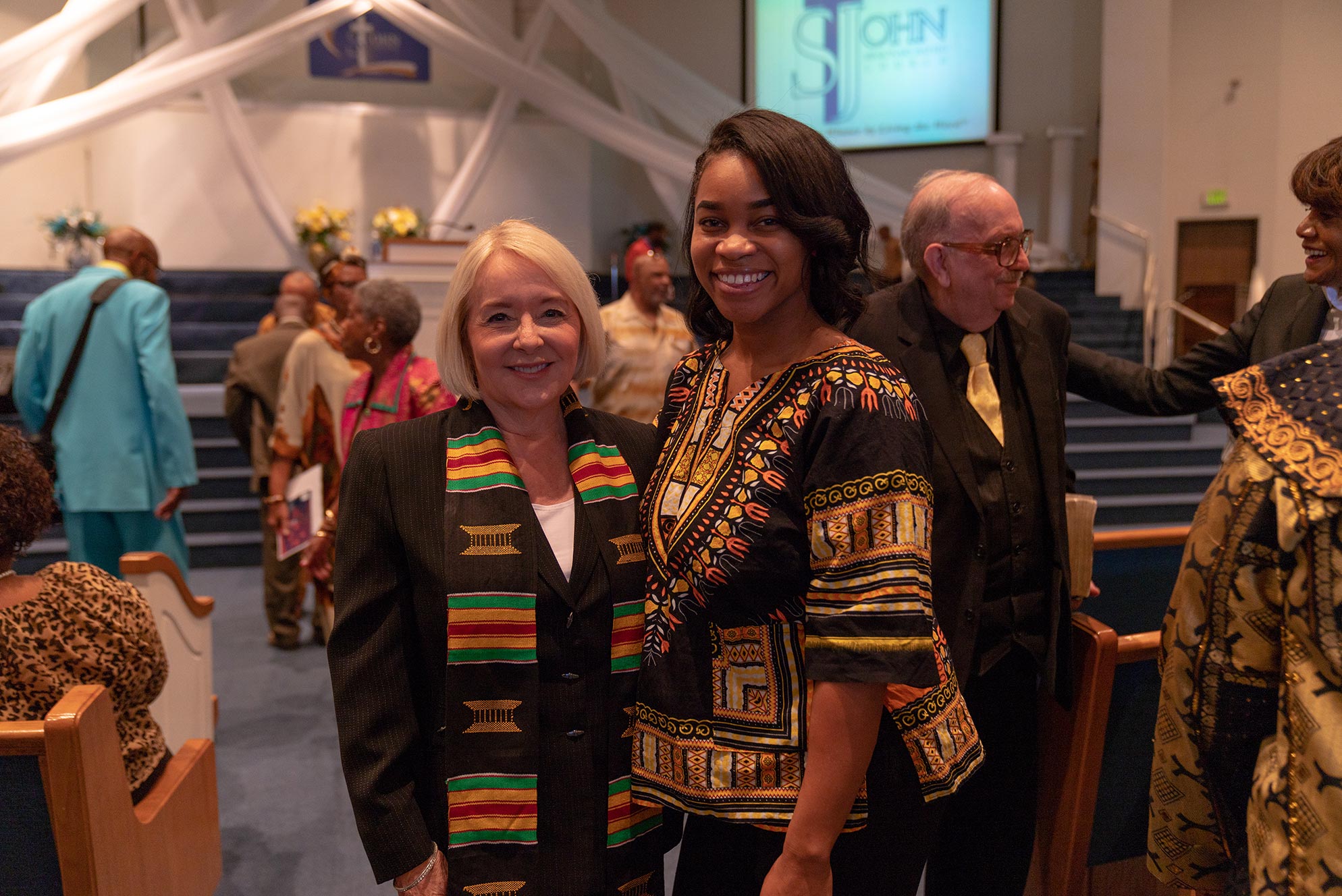Two women standing next to each other and smiling