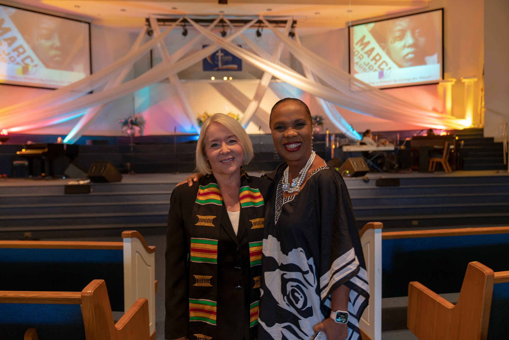 Two women standing next to each other and smiling