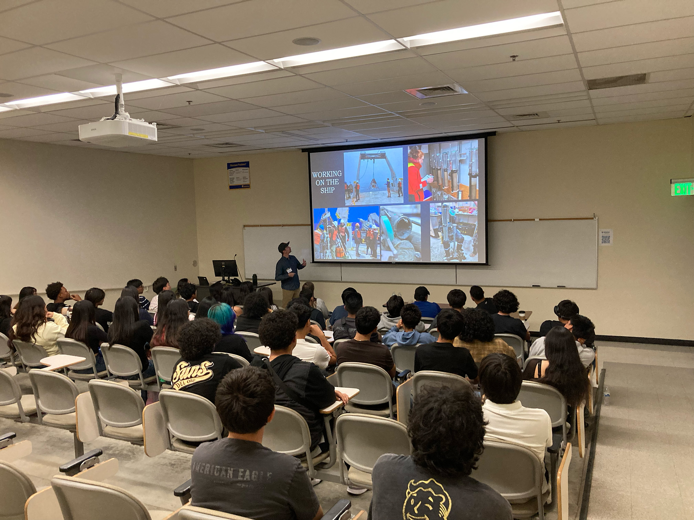 Student Ryan talks to the visiting students about his research experiences