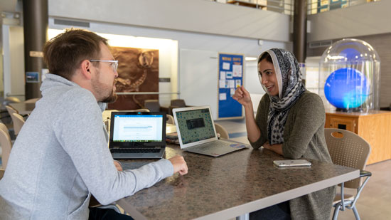 Two students sitting at a table and chatting