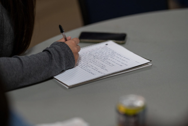 A student writing on a notebook