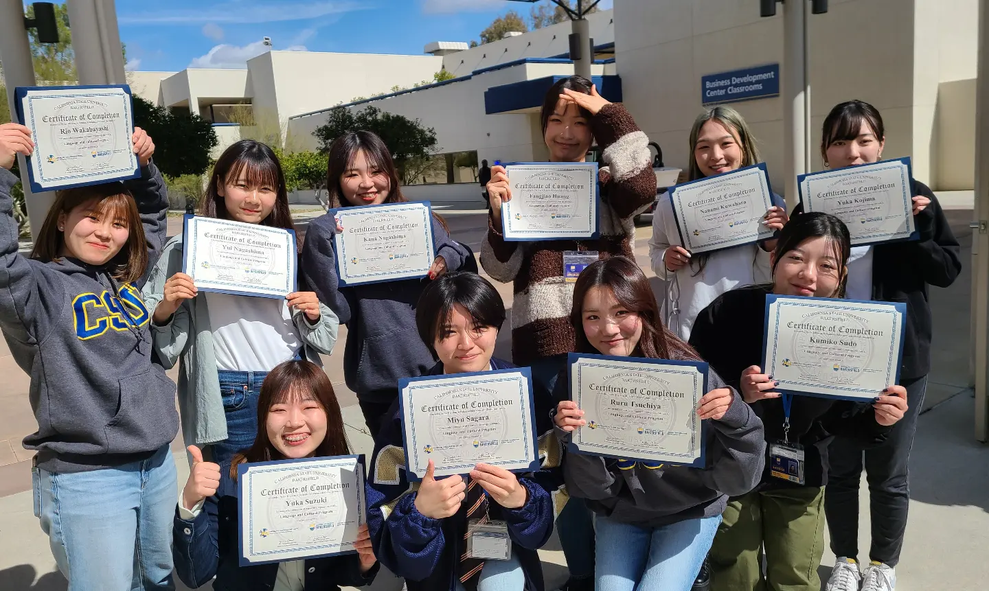 A group of international students holding up certificates