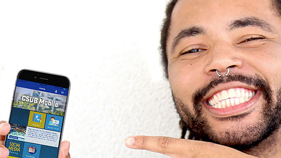 Man with beard smiling and pointing to a mobile device displaying the CSUB mobile app