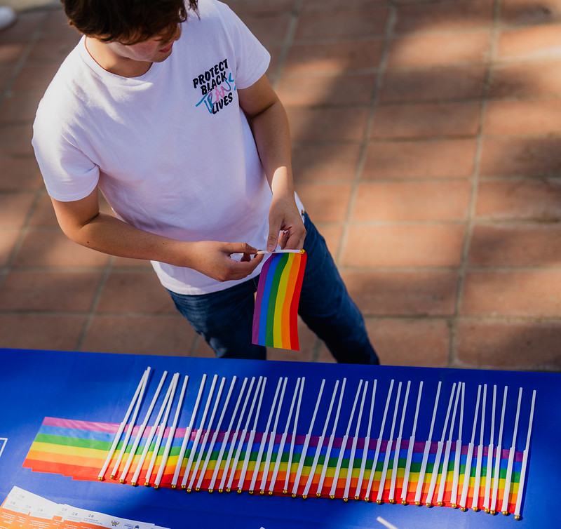 Man places rainbow flags onto a table