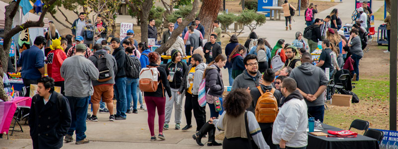CSUB students gathering near tables on campus