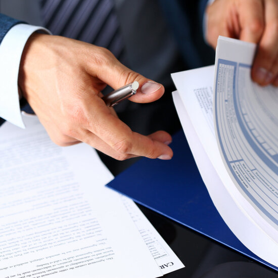 Male arm in a suit offering insurance paperwork