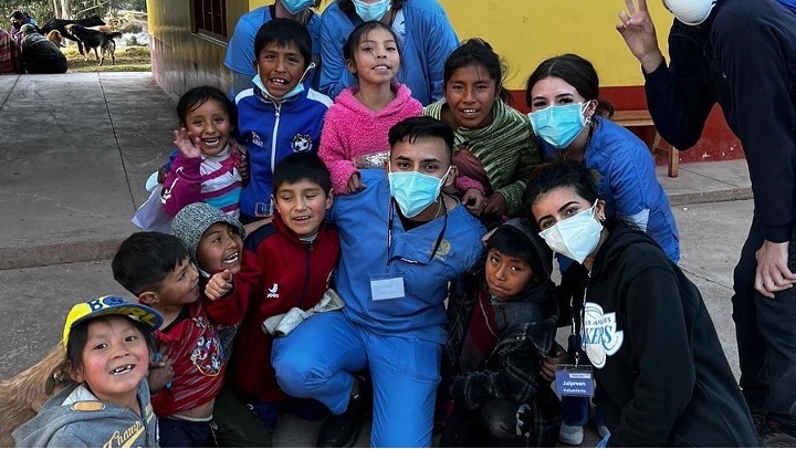 CSUB nursing student surrounded by smiling children in Cusco Peru