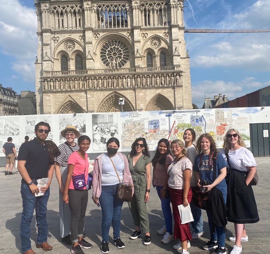 Students and a professor standing in front of Notre Dame in Paris, France
