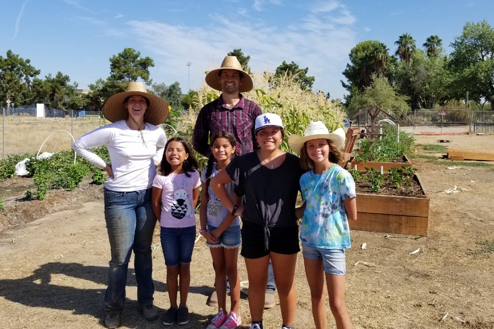 A family volunteering at the edible garden.