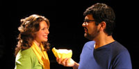 Actors smiling at one another in scene from student-written play.