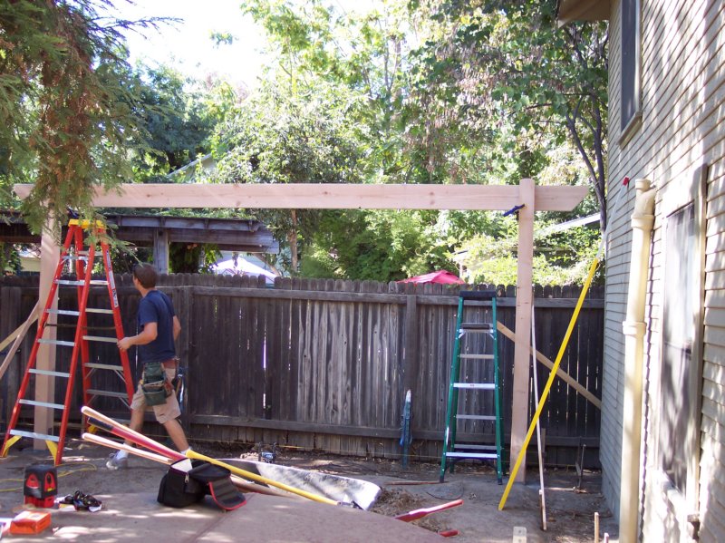 day2placingthe2x10spandrelbeamtoformtherearportionofthepergolaitslengthisapprox18feet.jpg
